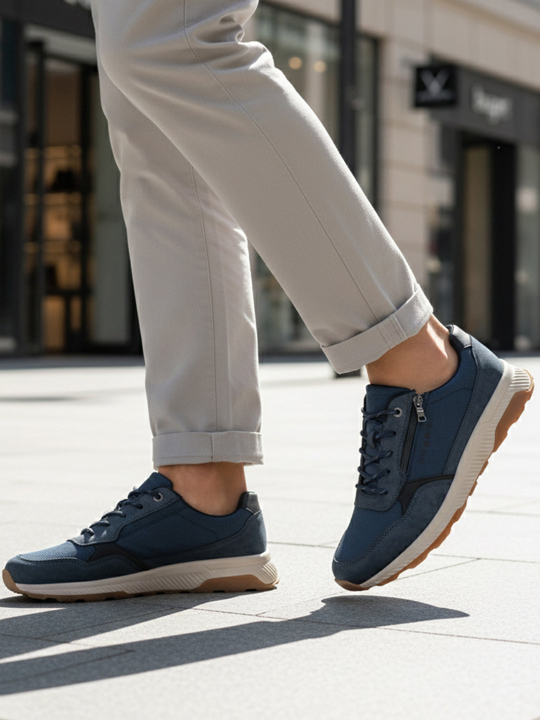 Lifestyle view of bugatti Jerit dark blue comfort sneakers with laces and a side zipper.
