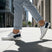 Lifestyle shot of bugatti Samana white leather sneakers with navy and red accents, worn with gray trousers.