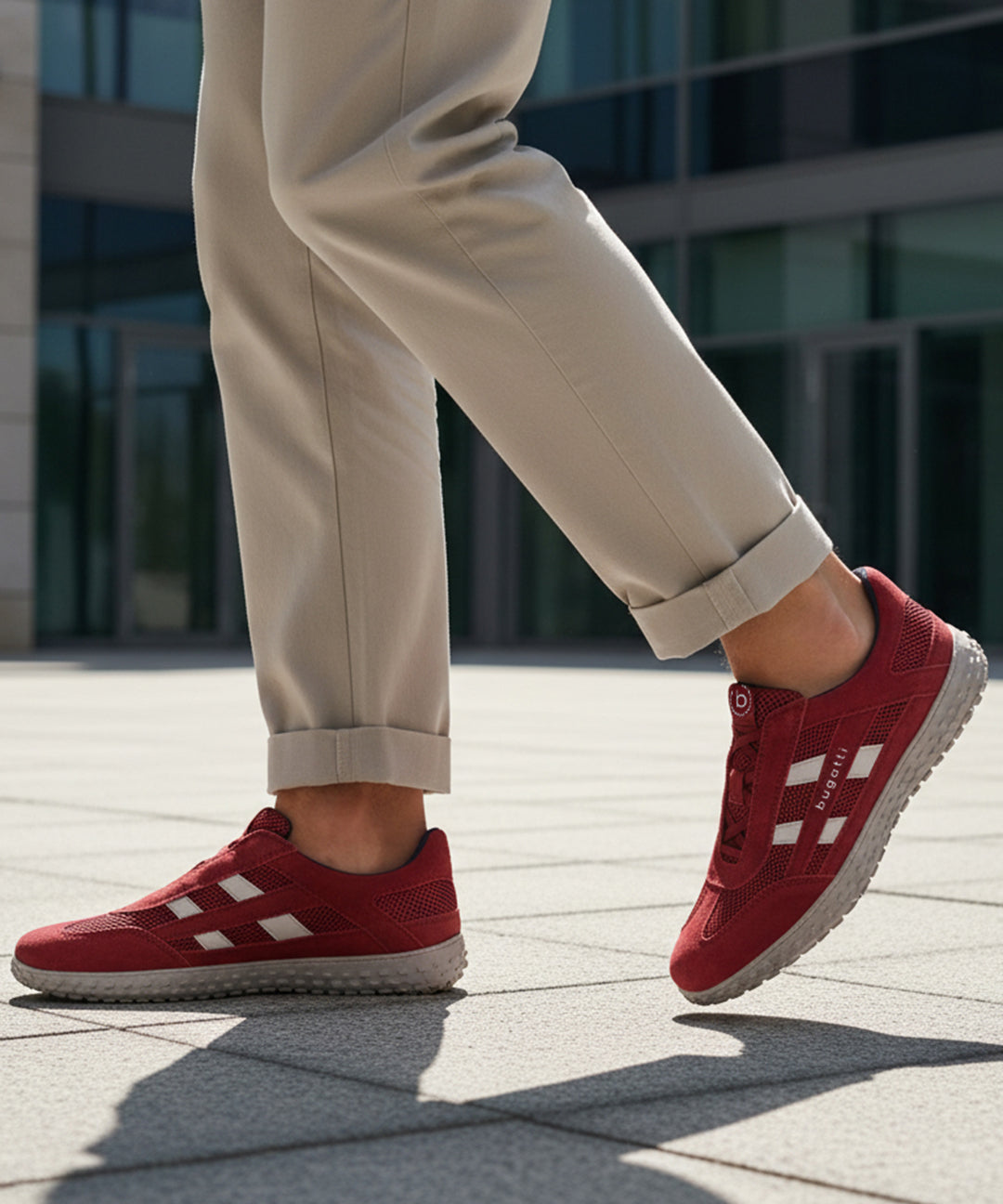 Lifestyle close-up of the bugatti Maddy dark red premium leather sneakers paired with khaki trousers.
