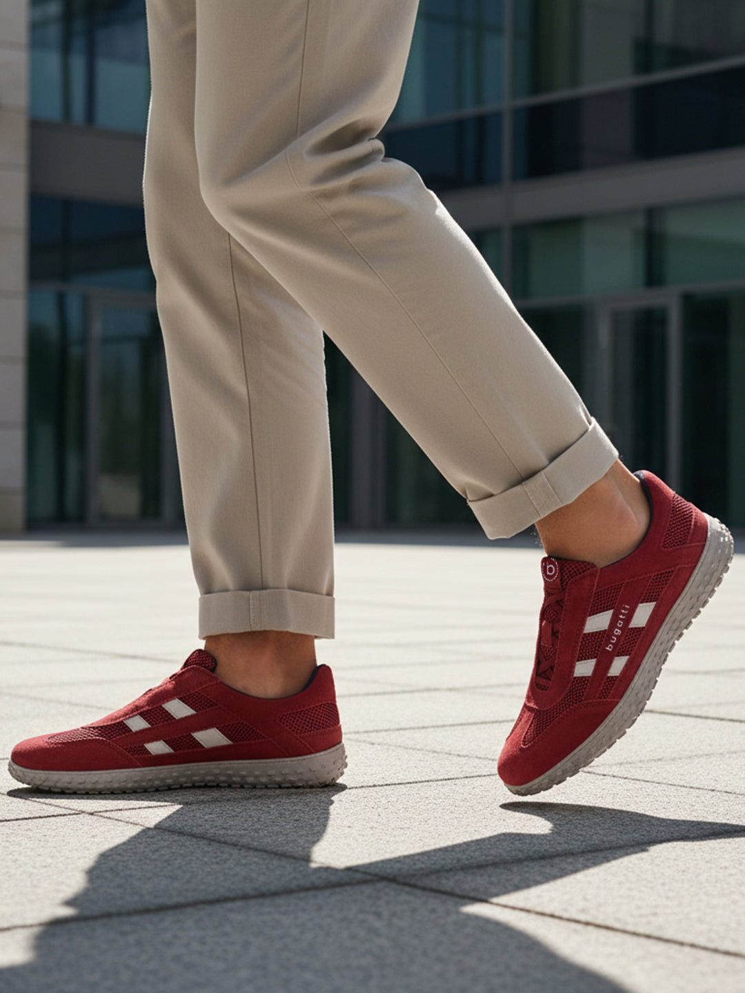 Lifestyle close-up of the bugatti Maddy dark red premium leather sneakers paired with khaki trousers.
