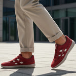 Lifestyle close-up of the bugatti Maddy dark red premium leather sneakers paired with khaki trousers.
