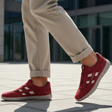 Lifestyle close-up of the bugatti Maddy dark red premium leather sneakers paired with khaki trousers.
