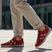 Lifestyle close-up of the bugatti Maddy dark red premium leather sneakers paired with khaki trousers.
