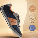 Casual navy and gray sneaker by bugatti, with orange accents and a tan leather band, in a studio shot.
