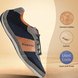 Casual navy and gray sneaker by bugatti, with orange accents and a tan leather band, in a studio shot.
