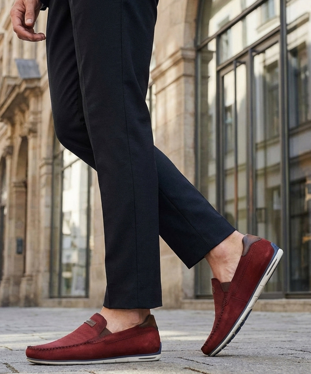 Lifestyle shot of bugatti Chesley dark red leather slip-on shoes, paired with dark dress pants.
