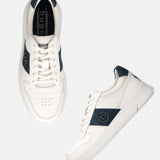 Off-white leather sneakers by bugatti with a dark blue accent, laces, and perforated toe.