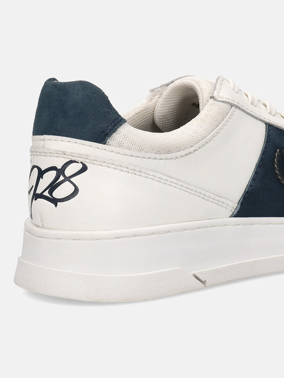 Off-white leather sneakers by bugatti with a navy heel accent and textured collar.