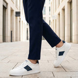 Lifestyle view of bugatti Franc off-white sneakers in premium leather with a navy stripe and white laces.