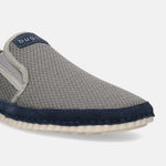 Light grey casual slip-on shoe by Bugatti featuring a textured upper, dark blue trim, and white sole.