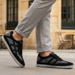 Lifestyle view of bugatti Baloo black leather sneakers with gray mesh detail and a chunky sole.

