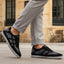 Lifestyle view of bugatti Baloo black leather sneakers with gray mesh detail and a chunky sole.
