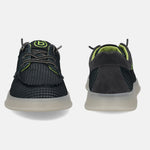 Black comfort sneakers by bugatti with textured upper, neon green accents, and translucent soles.