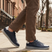 Lifestyle view of bugatti Fiero dark blue leather sneakers with a light grey sole and heel.