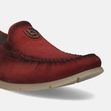 Red leather slip-on shoe by bugatti, featuring decorative stitching and a branded metal emblem.