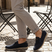 Lifestyle shot of bugatti Clipperton dark blue leather slip-on shoes with grey pants and iron chairs in the background.