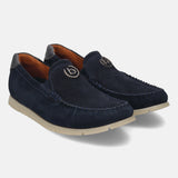 Dark blue leather slip-on shoes by bugatti, featuring a silver-toned logo emblem and contrast stitching.