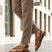 Lifestyle view of bugatti cognac leather sandals with adjustable back strap worn with tan pants.

