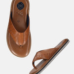 Brown leather thong sandals by bugatti, featuring toe-post styling and the brand name embossed on the strap.