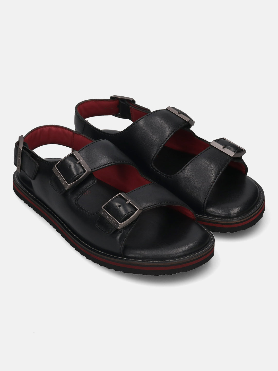 Pair of black bugatti leather sandals with buckle straps and red cushioned insoles.
