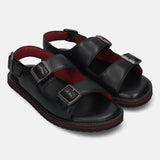 Pair of black bugatti leather sandals with buckle straps and red cushioned insoles.
