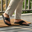 Lifestyle view of bugatti Cobie comfort thong sandals in black leather, paired with linen trousers.