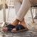 Lifestyle image of bugatti Cobie dark blue comfort cross strap sandals on a man wearing cuffed beige pants.