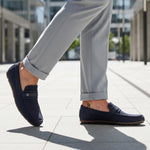 bugatti Corrado dark blue casual slip-on shoe, premium leather, being worn with gray dress pants.

