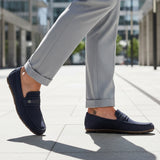 bugatti Corrado dark blue casual slip-on shoe, premium leather, being worn with gray dress pants.
