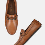 Cognac leather slip-on loafer by Bugatti, featuring metal accent and hand-stitched detailing.