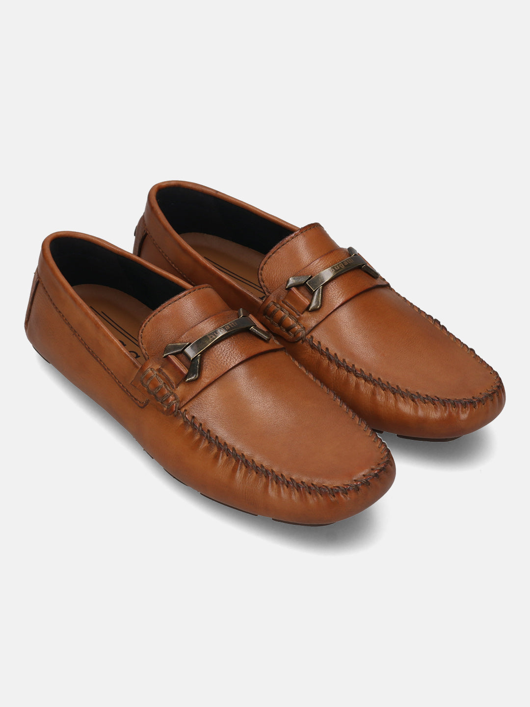 Cognac leather slip-on shoes by Bugatti, featuring decorative metal accents on the vamp and hand-stitched detailing.
