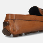 Cognac leather slip-on shoe by bugatti, showing the texture and dark brown rubber heel.