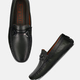 Dark green leather slip-on shoes by Bugatti with a decorative metal detail.