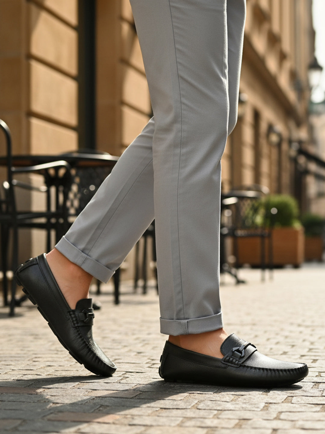 bugatti Olexa dark green leather slip-on shoe with decorative strap detail, worn with gray pants.
