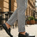 bugatti Olexa dark green leather slip-on shoe with decorative strap detail, worn with gray pants.
