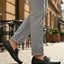bugatti Olexa dark green leather slip-on shoe with decorative strap detail, worn with gray pants.
