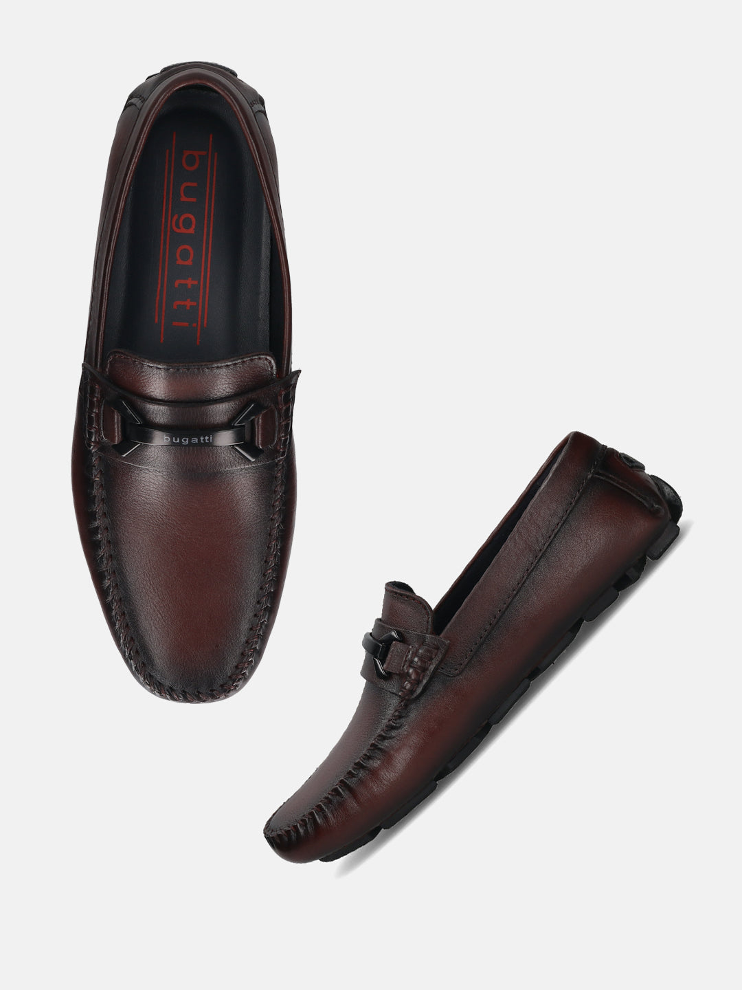Burgundy leather slip-on loafers by bugatti with a matte black buckle detail and decorative stitching.