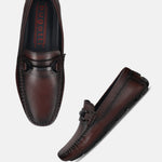 Burgundy leather slip-on loafers by bugatti with a matte black buckle detail and decorative stitching.