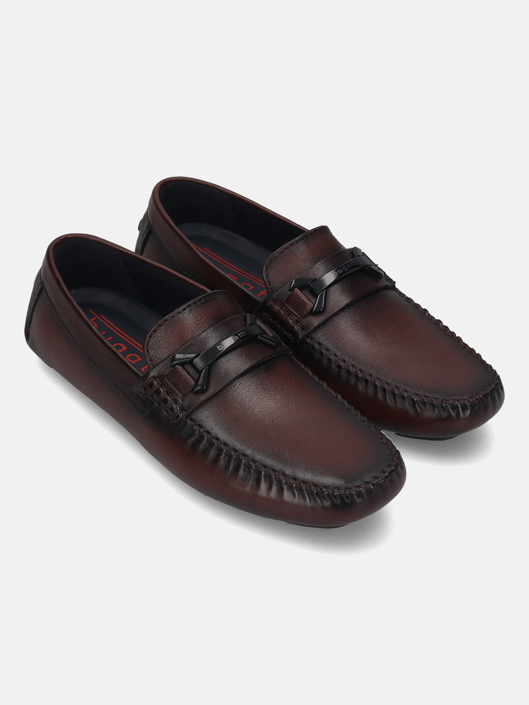 Burgundy leather slip-on shoes by bugatti, featuring a moc toe design and a decorative strap detail.