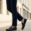 Lifestyle shot of bugatti Cobe Black premium leather slip-on shoes, paired with dark-colored pants.