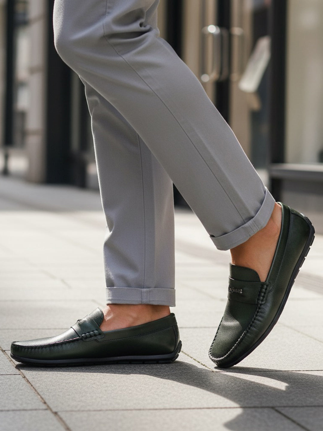 bugatti Linex dark green leather slip-on shoe with visible stitching, worn with gray dress pants.