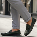 bugatti Linex dark green leather slip-on shoe with visible stitching, worn with gray dress pants.