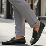 bugatti Linex dark green leather slip-on shoe with visible stitching, worn with gray dress pants.