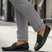 bugatti Linex dark green leather slip-on shoe with visible stitching, worn with gray dress pants.