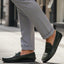 bugatti Linex dark green leather slip-on shoe with visible stitching, worn with gray dress pants.