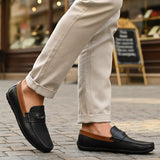 Lifestyle shot of bugatti Linex dark blue leather slip-on shoes with brown accents, paired with beige pants.
