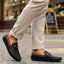 Lifestyle shot of bugatti Linex dark blue leather slip-on shoes with brown accents, paired with beige pants.

