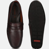 Brown bugatti leather slip-on shoe, featuring a moc toe and comfortable sole, shown alongside its textured outsole.