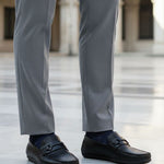 bugatti Linex black casual slip-ons in premium leather, worn with gray dress pants and dark socks.
