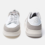 White leather sneakers by bugatti with gray suede accents and a contrasting platform sole.